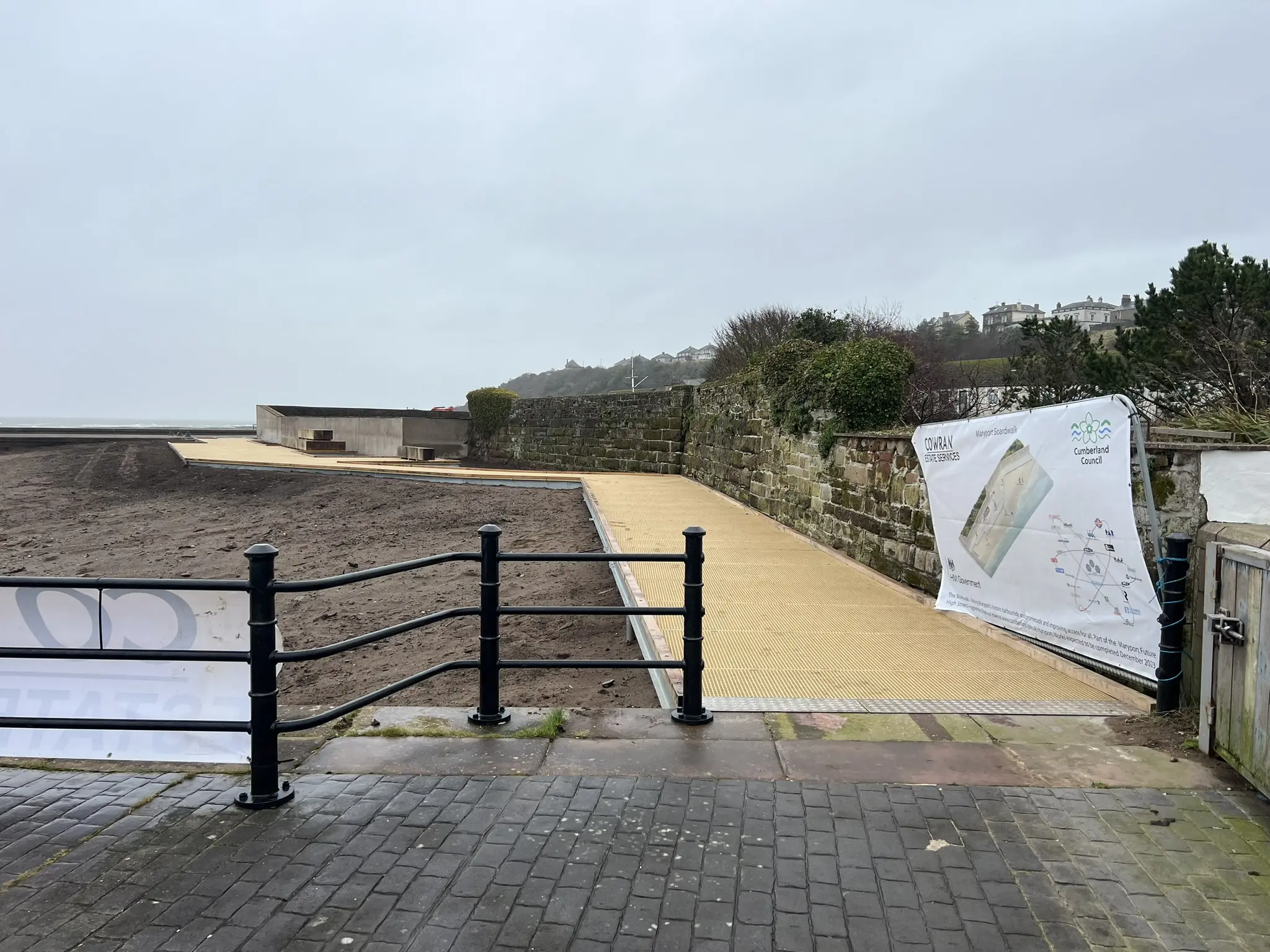 Completed Maryport Boardwalk entrance linking the harbour wall and promenade across the coastal site