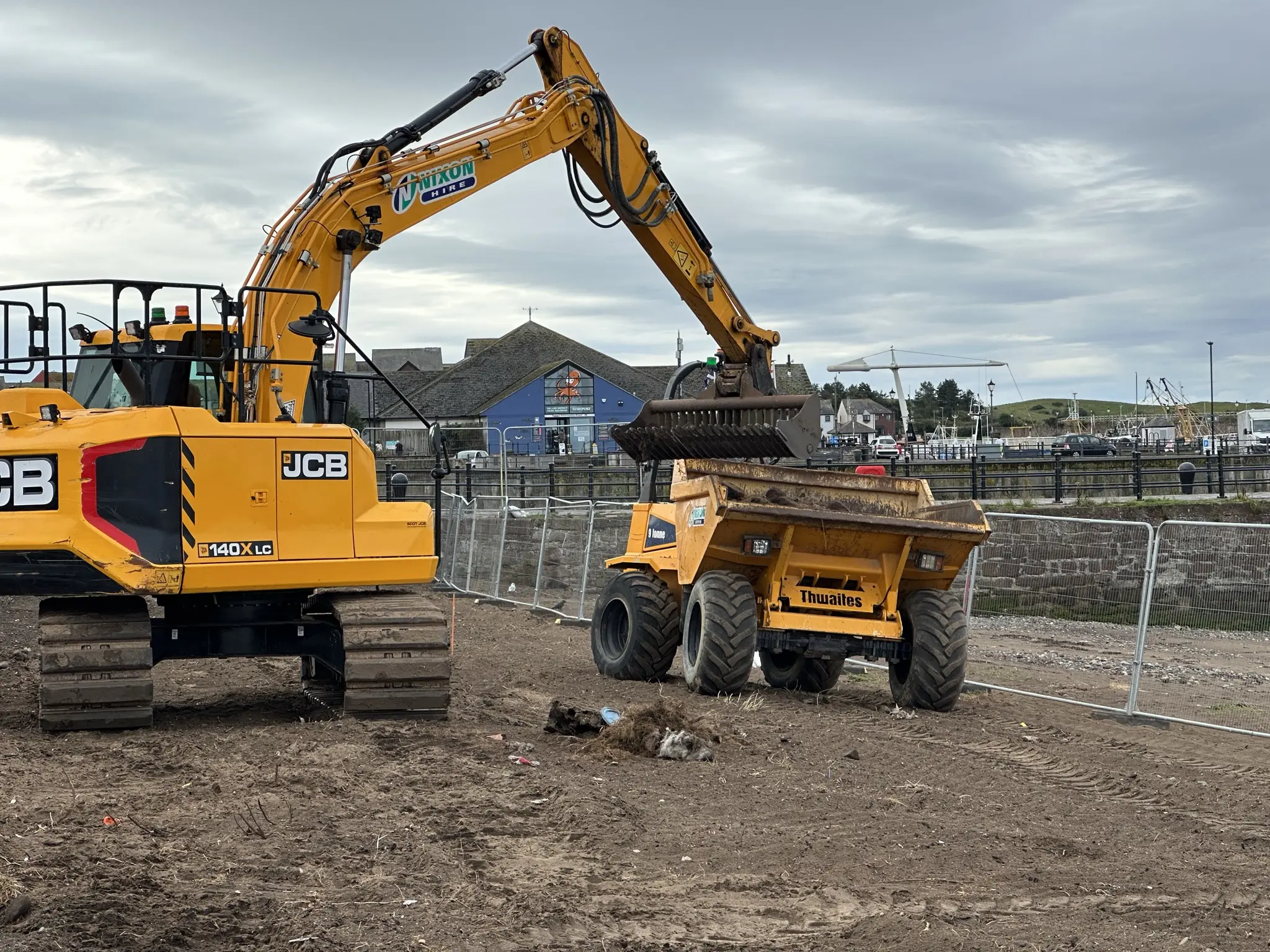 Excavator and dumper working on the Maryport Boardwalk earthworks beside the harbour