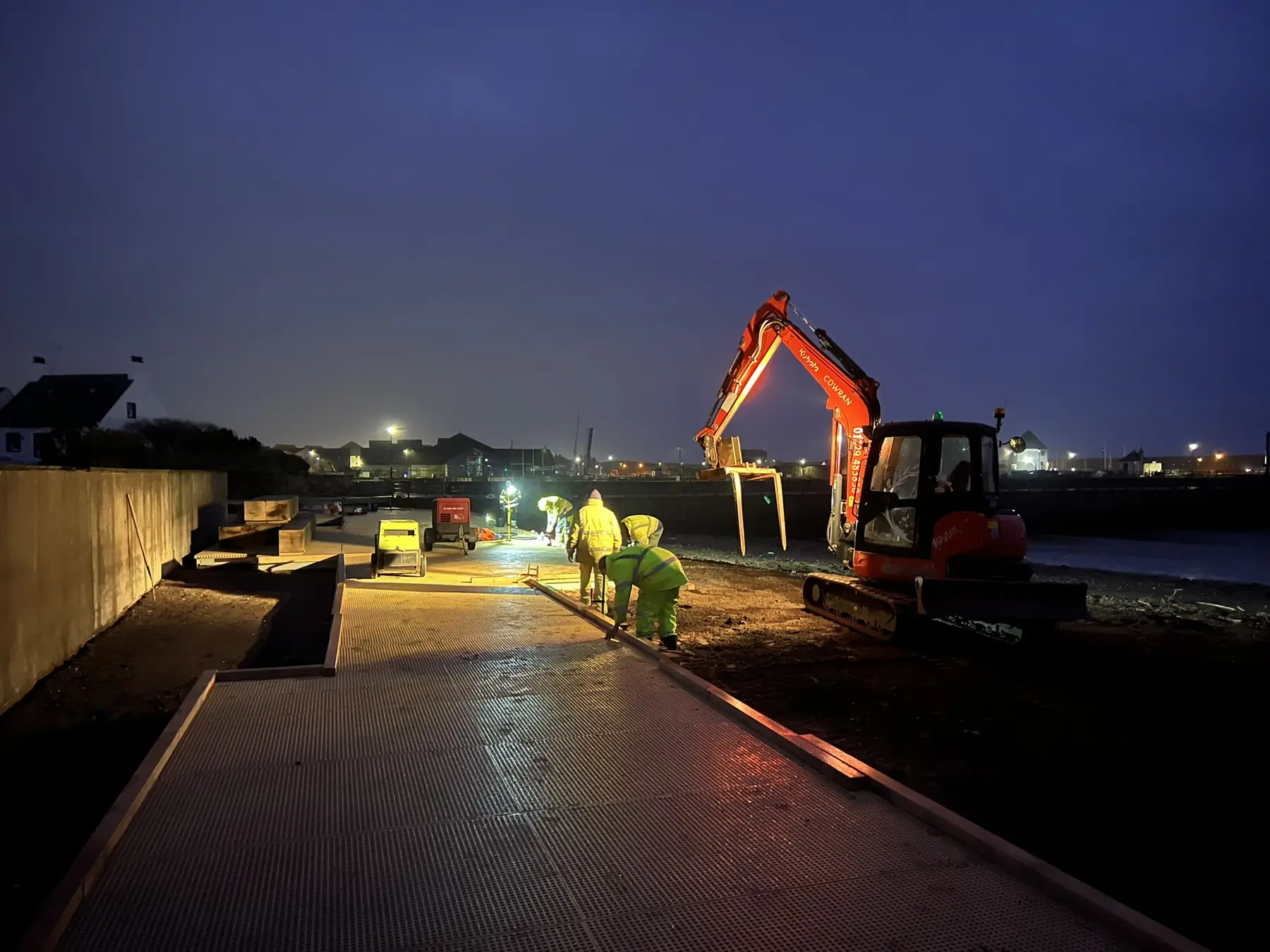 Cowran Estate Services team and excavator delivering the illuminated Maryport Boardwalk during night working
