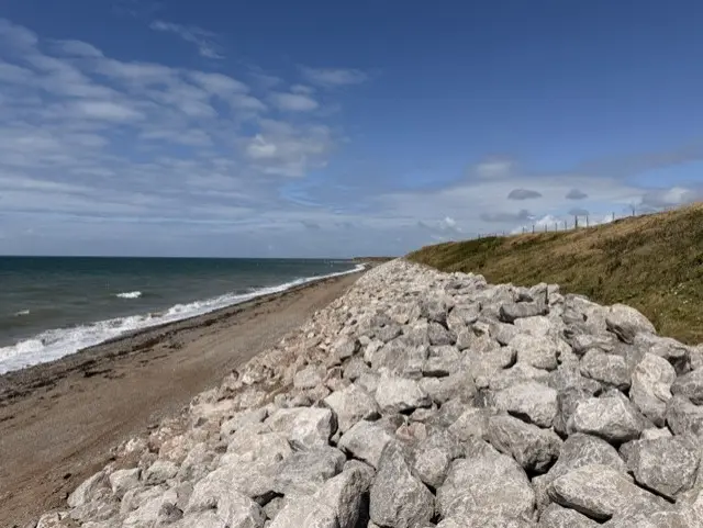Rock-armour coastal engineering beside the bright blue sea at South Walney